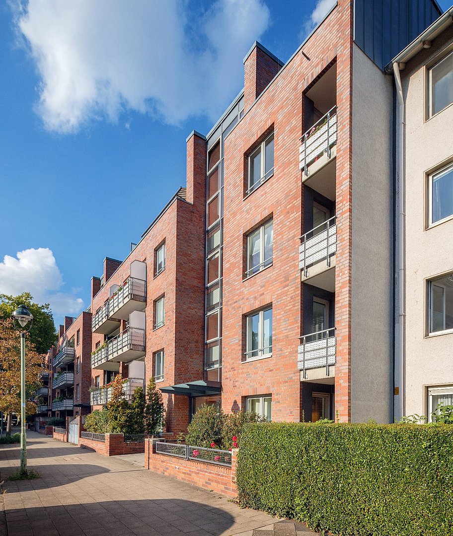 a building from the outside with balconies and windows in summer